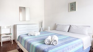 A neatly arranged bedroom with a bed, a chair, a dresser, and a framed picture on the wall. - Large apt 2 bedrooms &free car park (Venezia)
