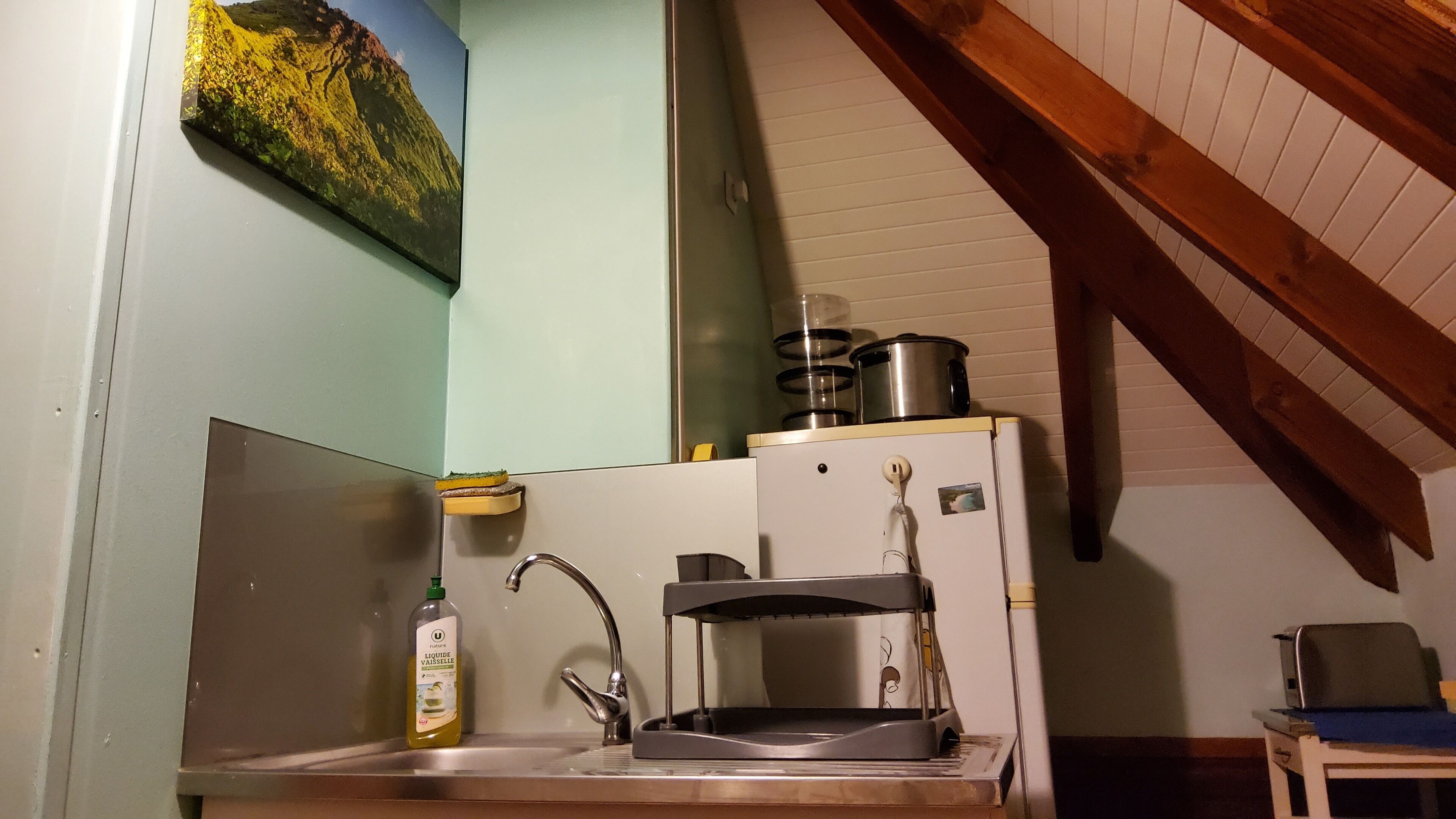 A compact kitchen with a sink, a small refrigerator, and a stove.