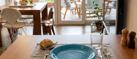 Une table à manger avec une assiette bleue, des couverts et une miche de pain.