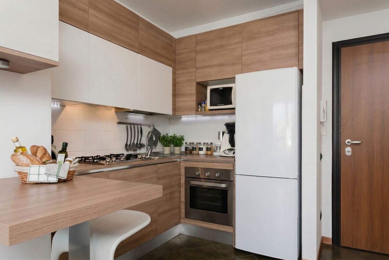 Une cuisine moderne avec des meubles en bois, un réfrigérateur blanc, un four et un four à micro-ondes.