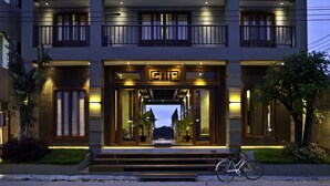A modern hotel with a prominent entrance, a bicycle parked outside, and a well-lit facade. - Chic Chiangkhan Hotel (Chiang Khan)