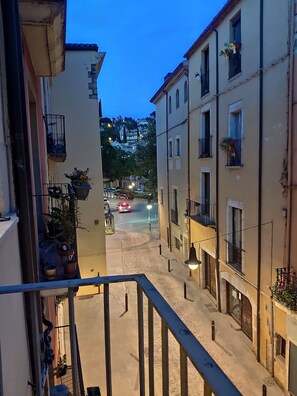 Stroll through a charming residential street lined with traditional buildings featuring balconies and windows.