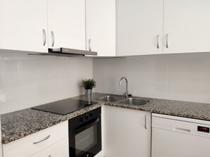 Enjoy cooking in this well-equipped kitchen with a granite countertop, white cabinetry, and stainless steel appliances.