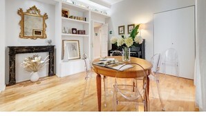 A dining area with a round table, clear chairs, a fireplace, and a bookshelf. - Downtown Rome, Vatican - St. Peter's area.  Elegant 3-bedroom, 2-bathroom apartment (Roma)