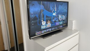Un televisor de pantalla plana montado en un mueble blanco en una habitación.
