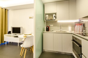A modern kitchen with white cabinets, a microwave, a coffee maker, and a sink.