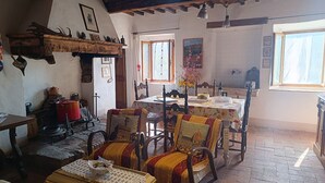 Un comedor rústico con una mesa de madera, sillas y una chimenea.