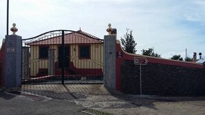 Ein verschlossenes Tor zu einem Gebäude mit einem Ziegeldach und einer Steinmauer.