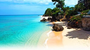 A beach with clear turquoise water, sandy shore, and lush greenery. - 2 Bed Apartment close to Dover Beach (Oistins)