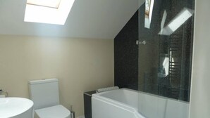 Un baño moderno con inodoro, lavamanos y bañera.