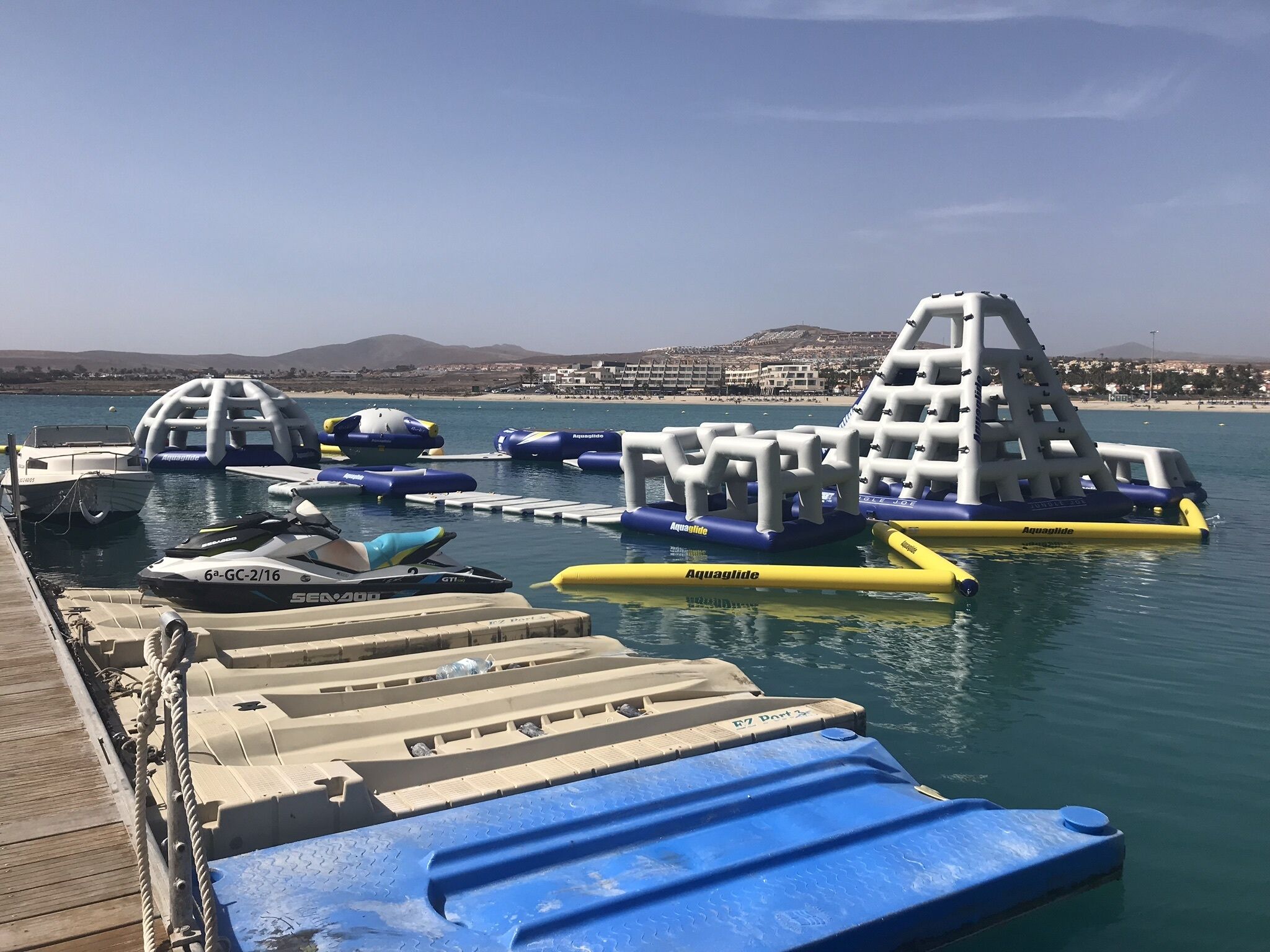 A marina with various watercraft, including boats and inflatable water structures.