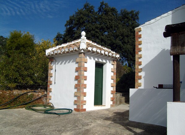 A small, white building with a green door and a tiled roof. - September with climate of 30 C plus for the month so come and enjoy yourselves. (Iznajar,Cordoba)