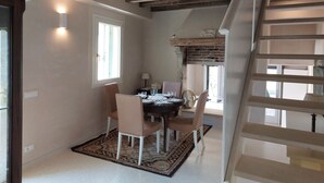 A dining area with a rustic ceiling, a dining table set with chairs, and a staircase leading to an upper level. - Luxury cottage, big terrace, marvelous view (Brendola)