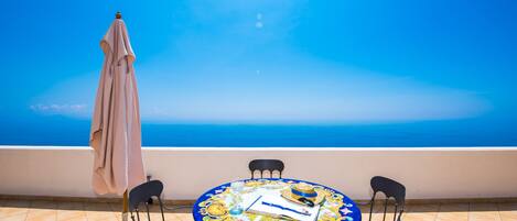 Ein runder Tisch mit blauer Tischdecke, vier Stühle und ein Buch sowie ein Hut darauf.