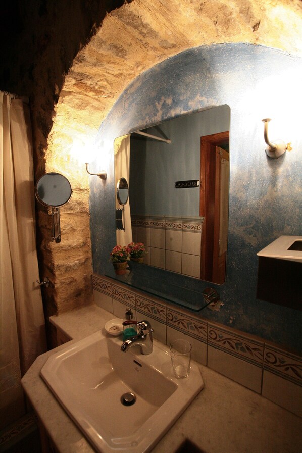 Ein Badezimmer mit Waschbecken, Spiegel und dekorativen Fliesen.