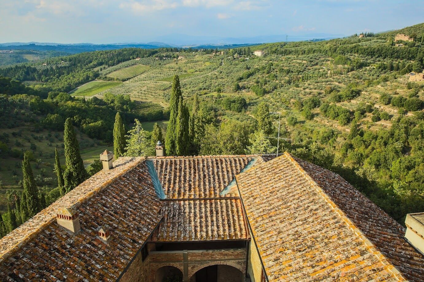 Un edificio con tetto in terracotta e vista su una valle rigogliosa.