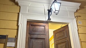 A wooden door with a white trim, a metal gate, and a light fixture above. - For My Friends B & B - Sun Room (Roma)