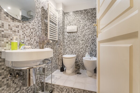 A bathroom with a white sink, a toilet, and a bidet. - For My Friends B & B - Sun Room (Roma)