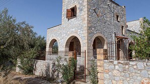 Un bâtiment en pierre doté de trois portes en arc de cercle et d’une petite fenêtre.