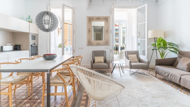 Um interior moderno com área de refeições, assentos e vista para o exterior.