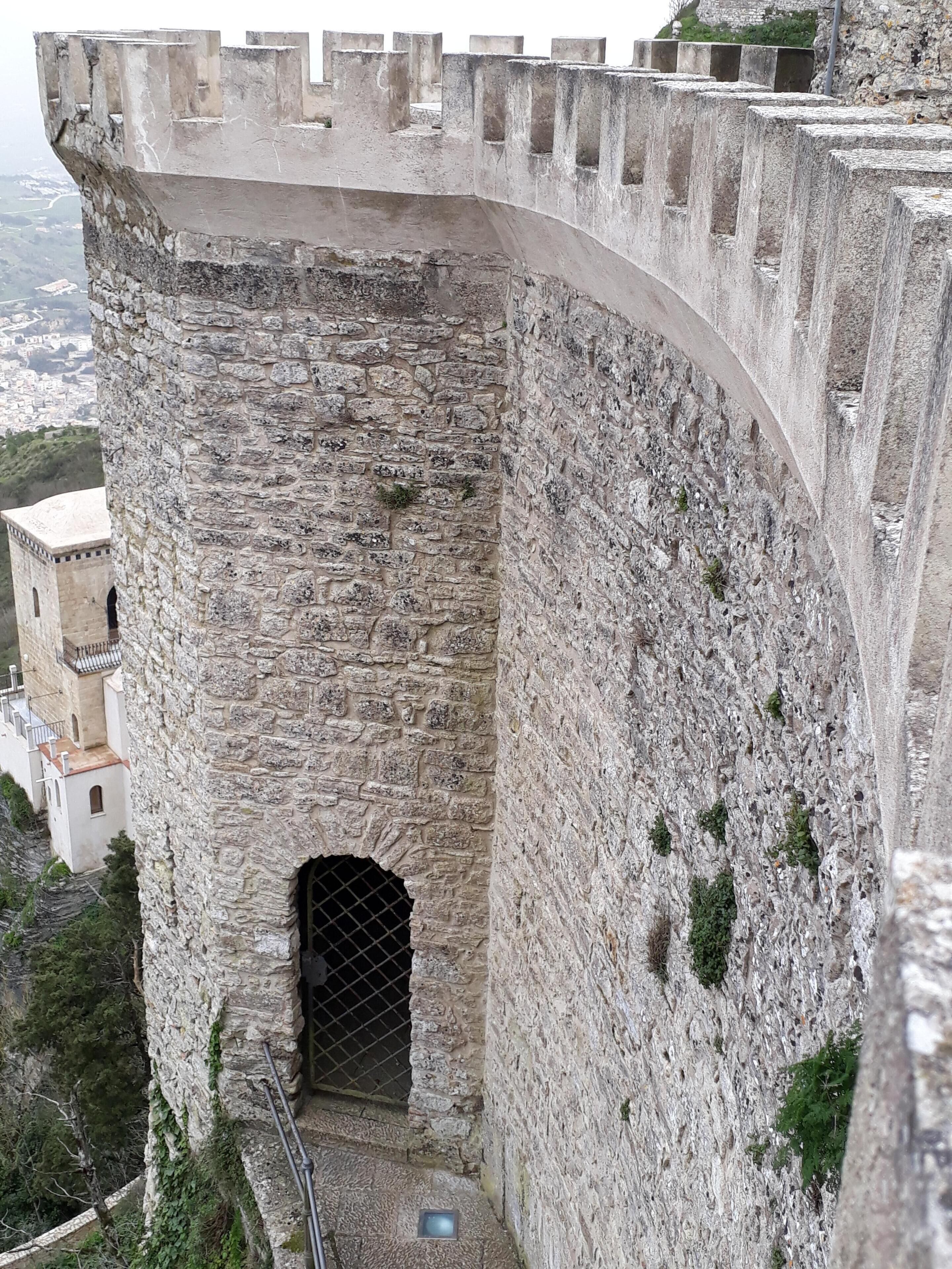 A stone fortress with a large arched entrance and a small window.