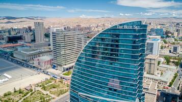 A modern building with a curved glass facade and the name "The Blue Sky" on top.