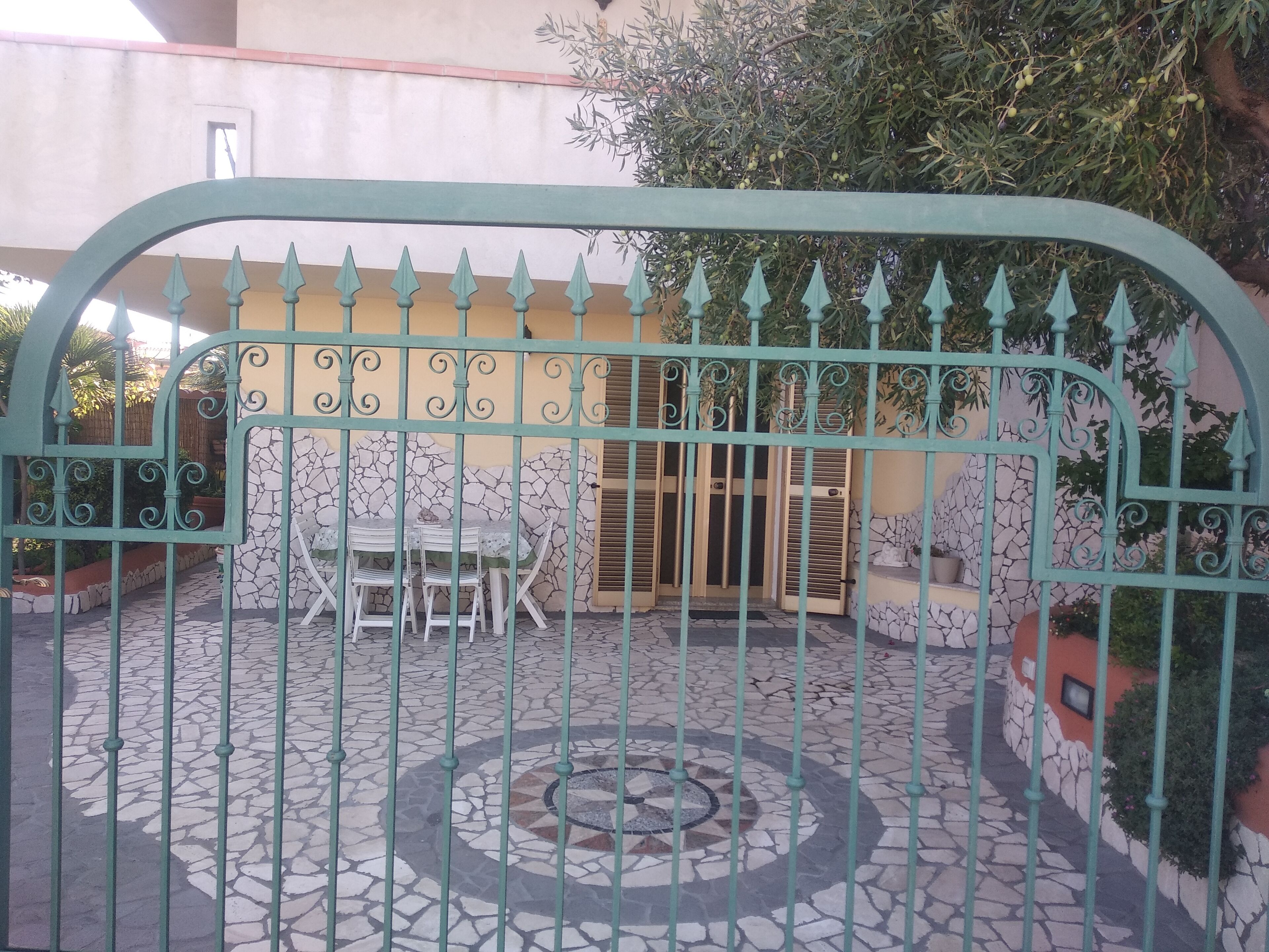A gated patio area with a tiled floor and a table with chairs.