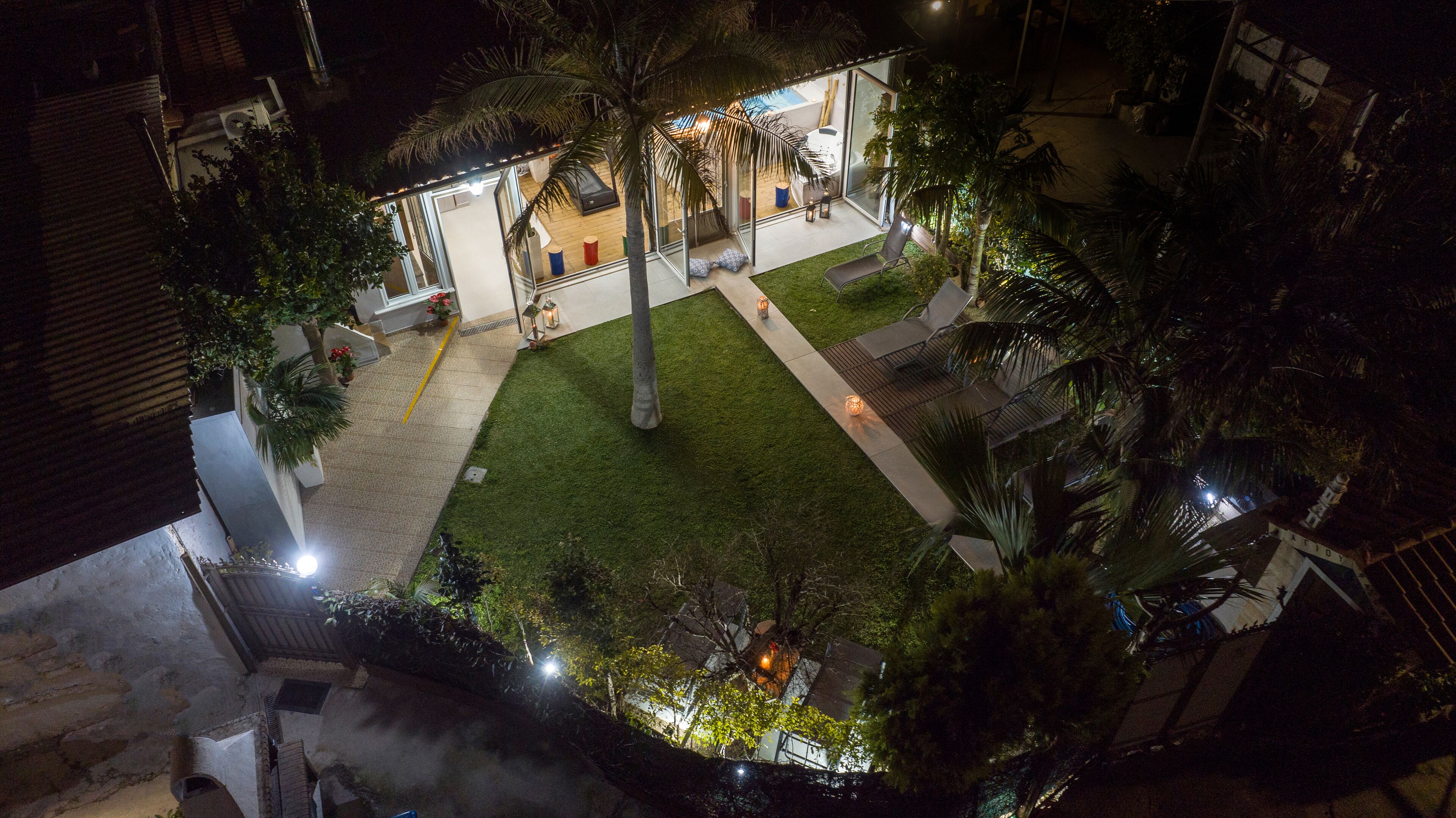 A courtyard with a pool, palm trees, and outdoor seating.