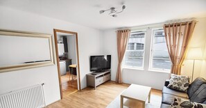 Apartamento superior, 2 habitaciones, planta baja | Zona de estar | Una televisión de pantalla plana, un reproductor de DVD