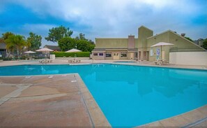 Relax by the pool surrounded by lounge chairs and umbrellas.