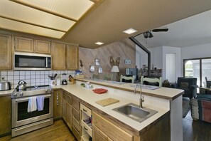 Enjoy cooking in the well-lit kitchen with a central island, sink, microwave, and oven.