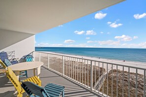 Ein Balkon mit Blick auf Strand und Meer.