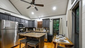 A modern kitchen with granite countertops, stainless steel appliances, and a large island with bar stools.