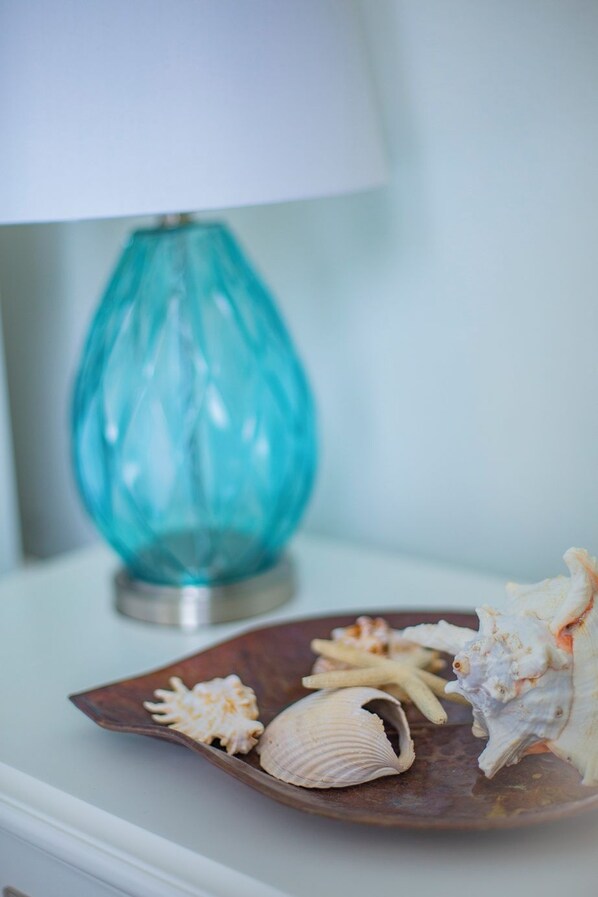 Una mesa con una lámpara decorativa y un plato de caracoles.