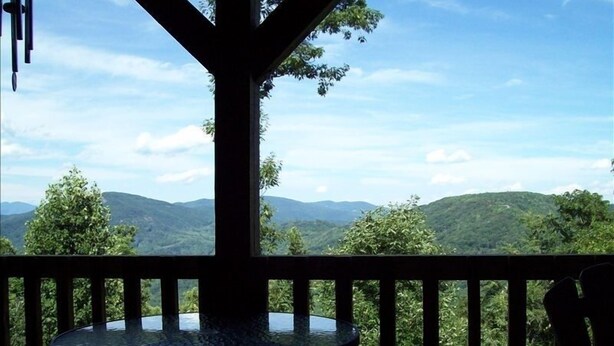 A balcony with a glass table and a view of a mountainous landscape. - Rustic Cabin, Appalachian Elegance,  Rural But Close (Asheville)