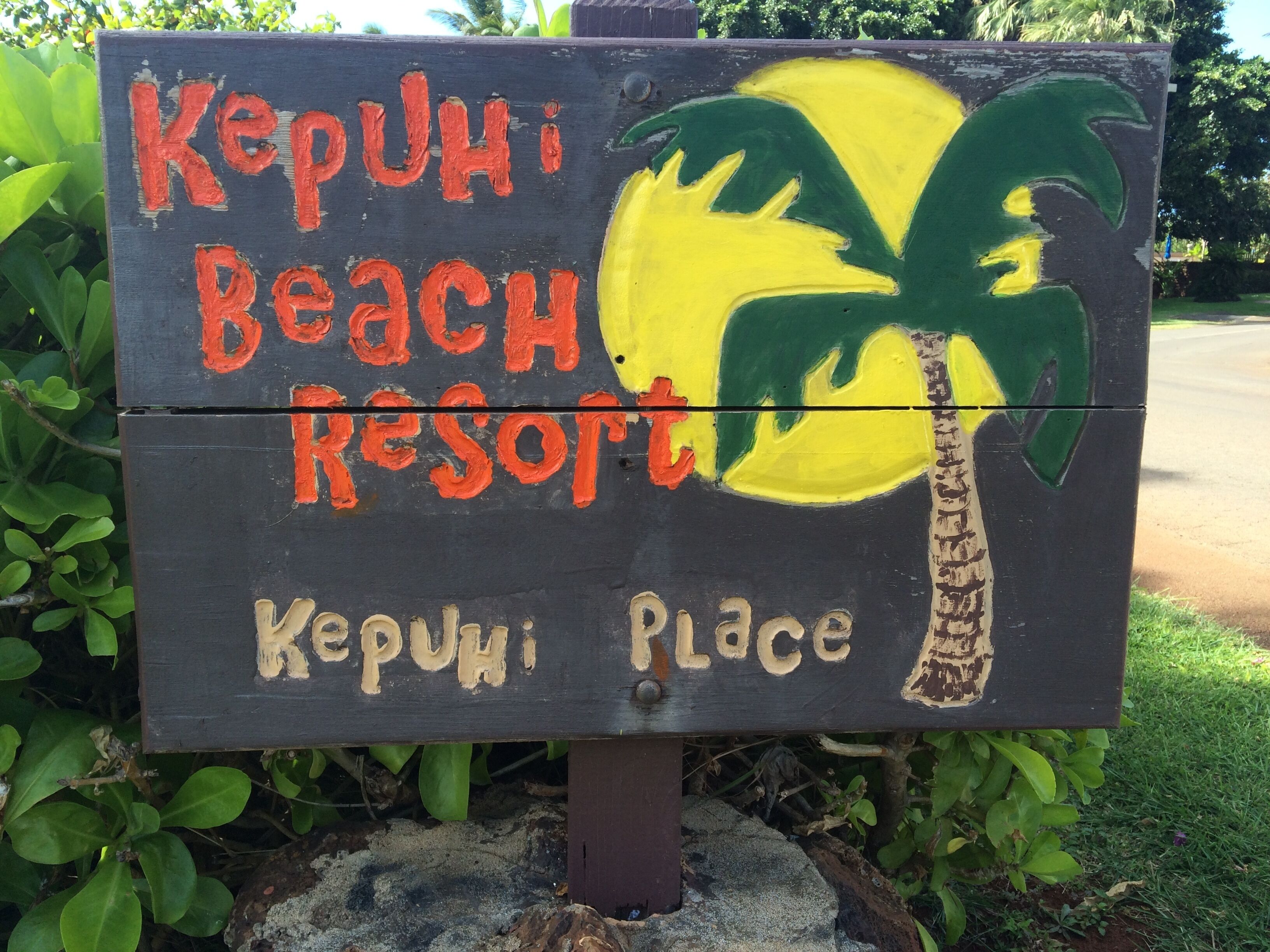 A wooden sign with 'Kerui Beach Resort' written in red and yellow.
