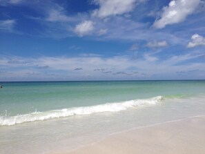 A beach with clear turquoise water and a sandy shore.