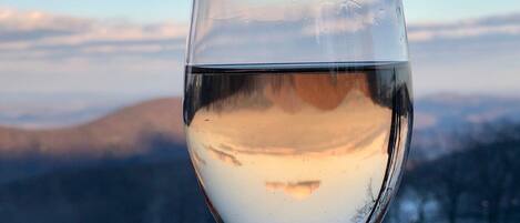 A clear glass of water with a mountain landscape in the background.
