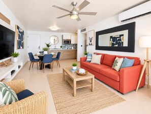 Una sala de estar moderna con un sofá, una mesa de centro y un comedor con sillas y una mesa.