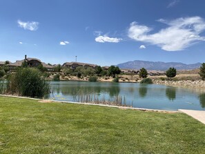 Escape to a serene lakeside retreat with a well-maintained lawn and breathtaking views of the surrounding mountains.