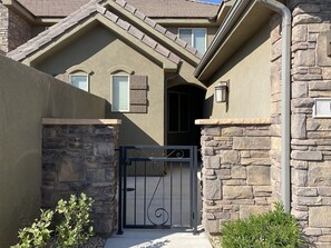 Stylish entrance with a metal gate and covered entryway.