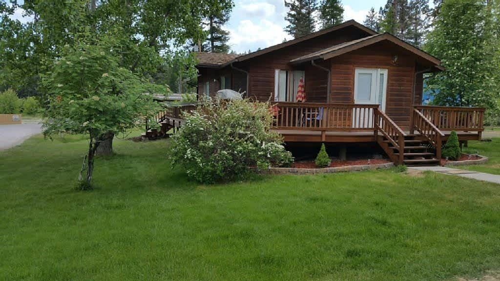 A wooden cabin with a front porch and a staircase leading to the entrance.