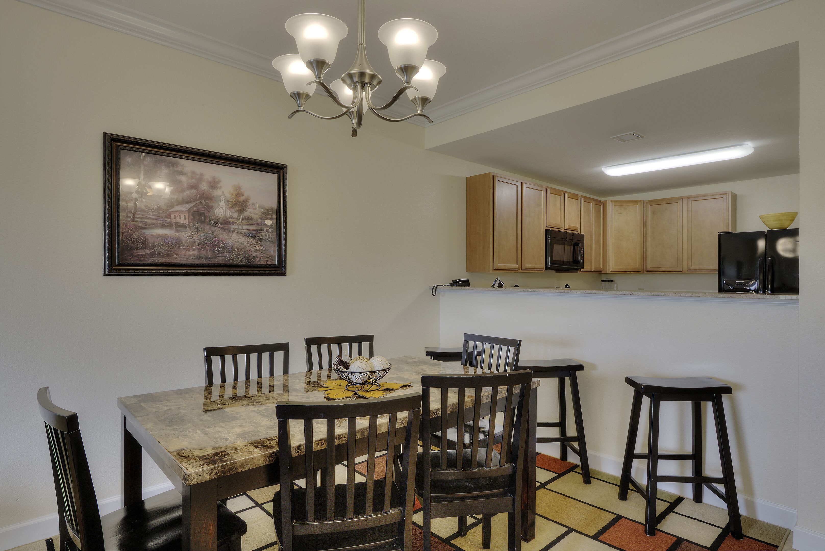Un espace repas comprenant une table, des chaises et un lustre.
