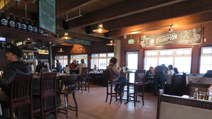A restaurant interior with wooden furniture, a bar area with bottles, and a chalkboard menu. - Ocean View Oasis Retreat. Comfort, plus great views! Sleeps 4. (Neskowin)