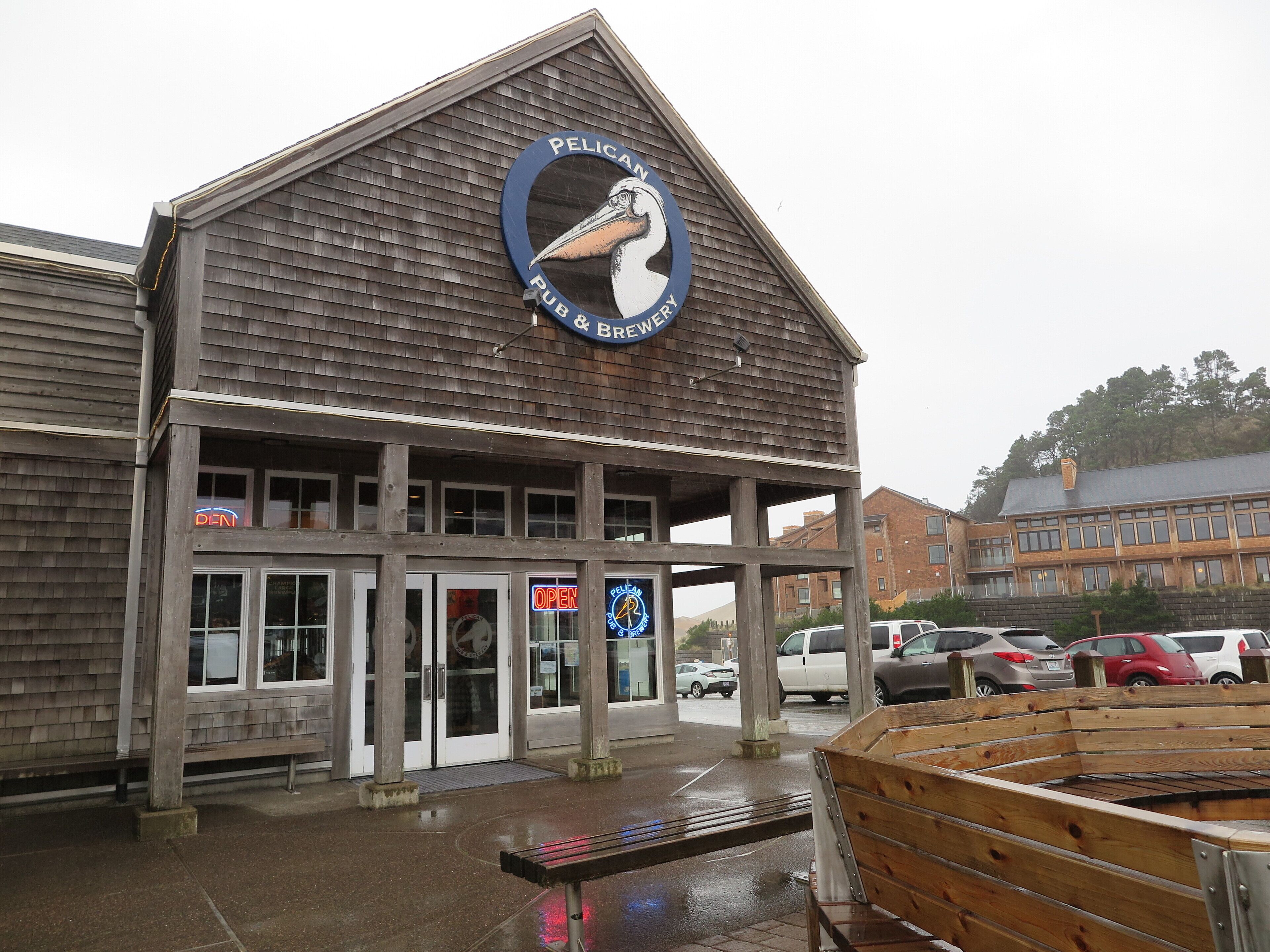 A wooden building with a sign reading "Pelican Pub & Brewery".