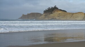 A beach with a rocky outcrop in the background. - Ocean View Oasis Retreat. Comfort, plus great views! Sleeps 4. (Neskowin)