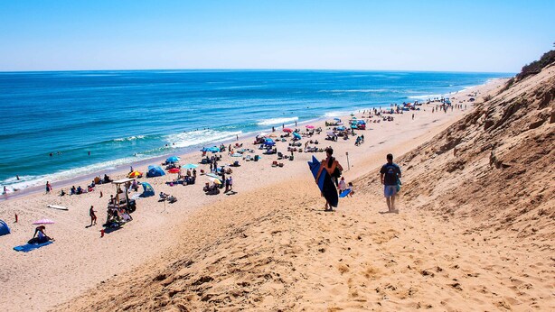 A beach with people, umbrellas, and a sandy slope. - Beachside Location at Lecount Hollow With A/C (Wellfleet)
