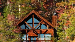 Eine Hütte mit markantem Holzbau, großen Fenstern und einem Balkon.