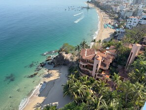 Un hôtel en bord de mer offrant une vue sur la plage, doté de plusieurs balcons et d’un espace piscine.