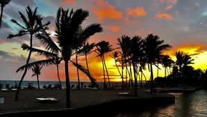 A beach with palm trees and a sunset. - Penthouse - 3 Bedrooms 2 Baths (Puako)